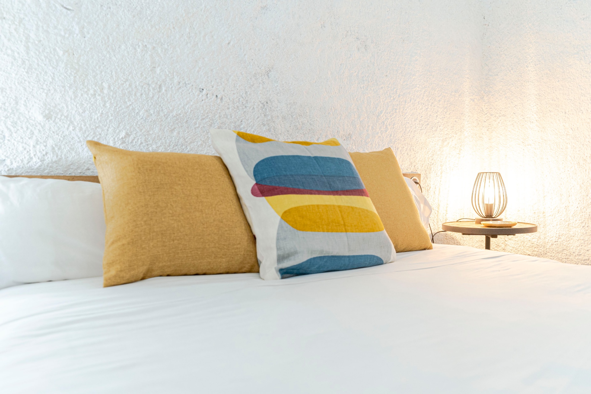 Detalle: textiles cálidos y luz ambiental sobre cama king